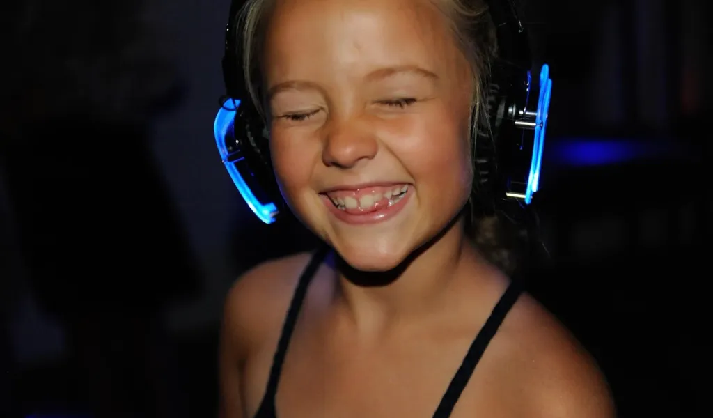 Uczniowie na szkolnej dyskotece silent disco w świecących słuchawkach