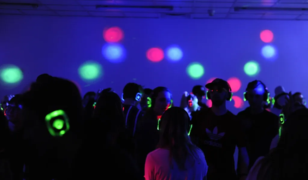 Goście tańczący na imprezie urodzinowej silent disco